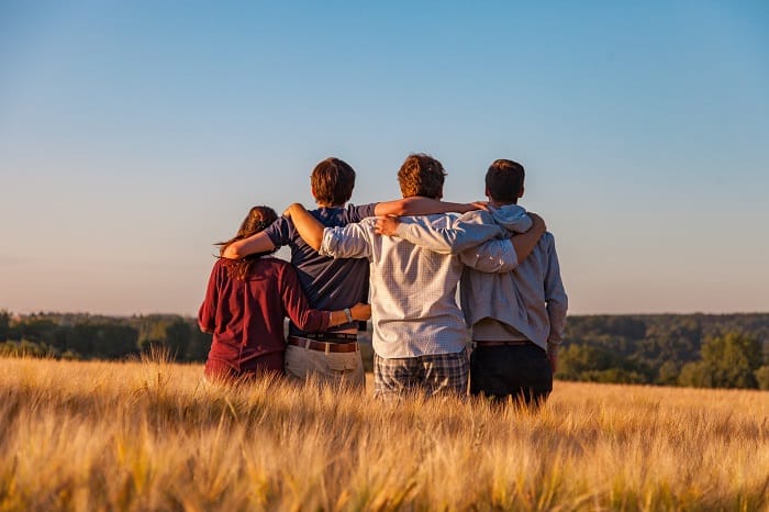 Friends embracing in a field after a stay at a drug and alcohol rehab in the West Midlands