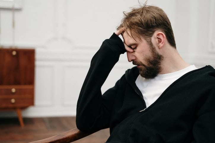 Man holding his head whilst in therapy at a drug and alcohol rehab in Hertfordshire or near Hertfordshire