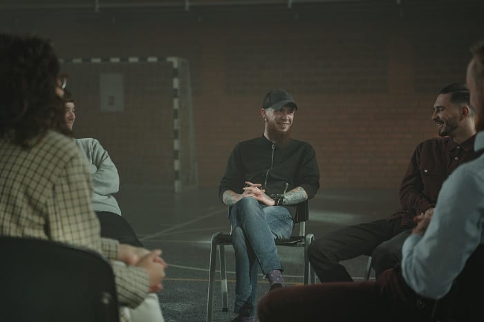 People smiling during a mutual support group at a drug and alcohol rehab in the West Midlands