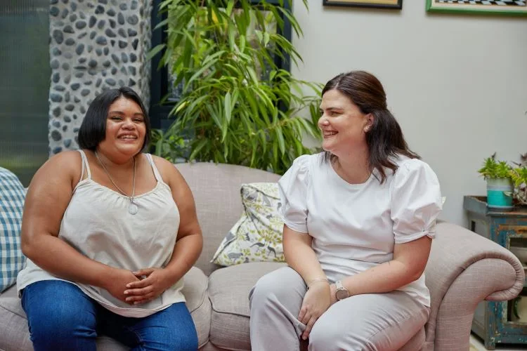 Two women sitting on the sofa having a conversation in Hampshire