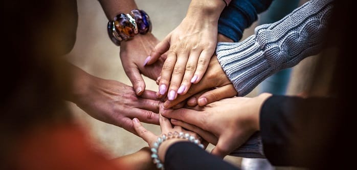 Support group holding hands at a drug and alcohol rehab centre in Scotland