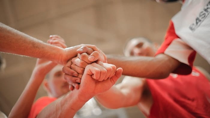 Support group holding hands at a drug and alcohol rehab clinic in Swansea