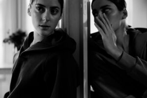 Woman doubled one whispering to the other representing dual diagnosis in substance abuse