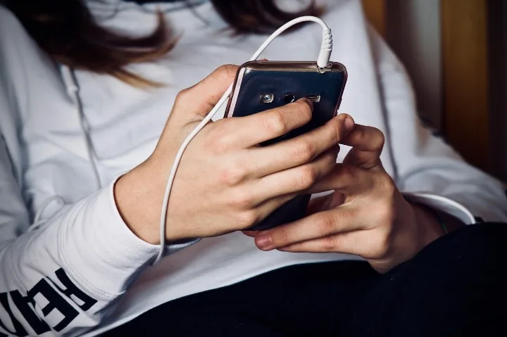 Woman typing on her phone at a drug and alcohol rehab in Middlesbrough