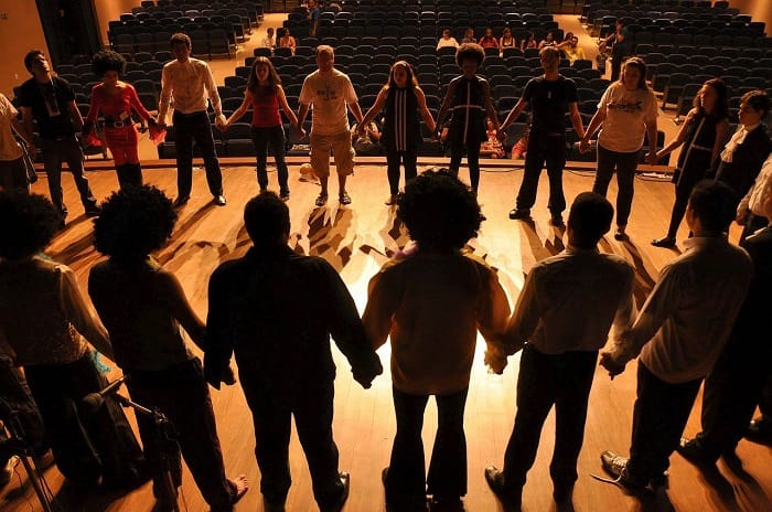 Support group standing and holding hands at a drug and alcohol rehab in Lancaster