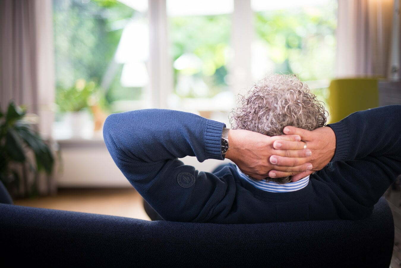 man with hands behind his head