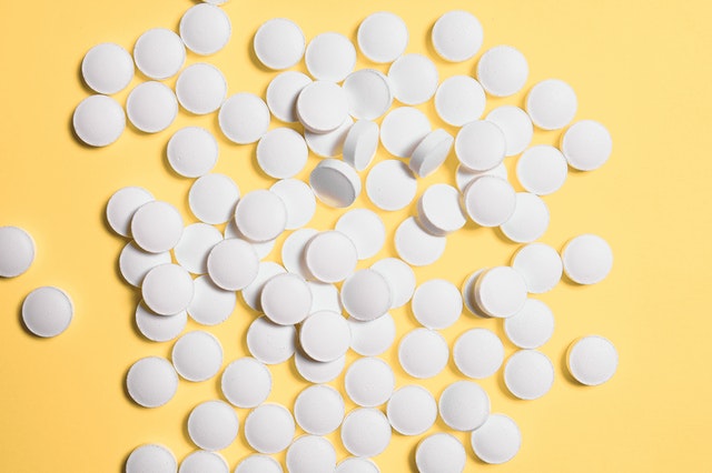 scatter of pills on yellow background