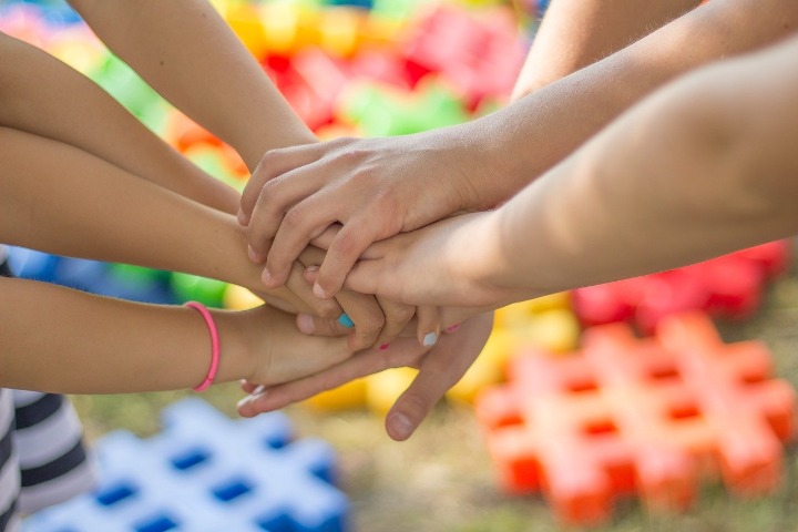 Photo of hands joined together in symbol of unity.
