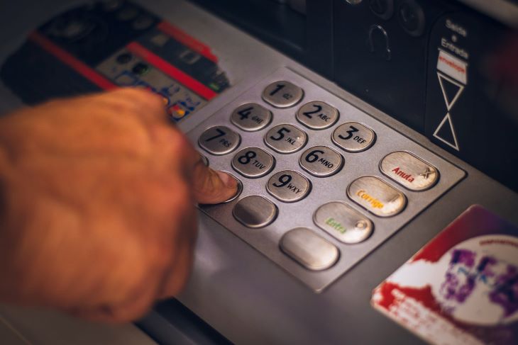 A person inputting their pin into an ATM machine