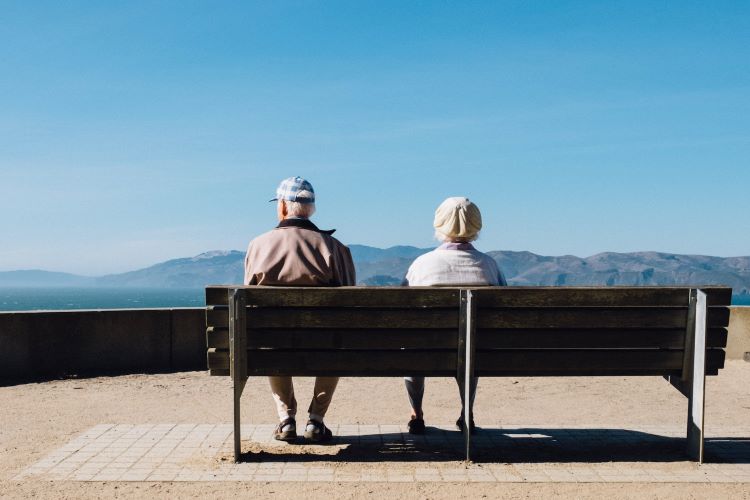 An elderly couple sitting on a bench