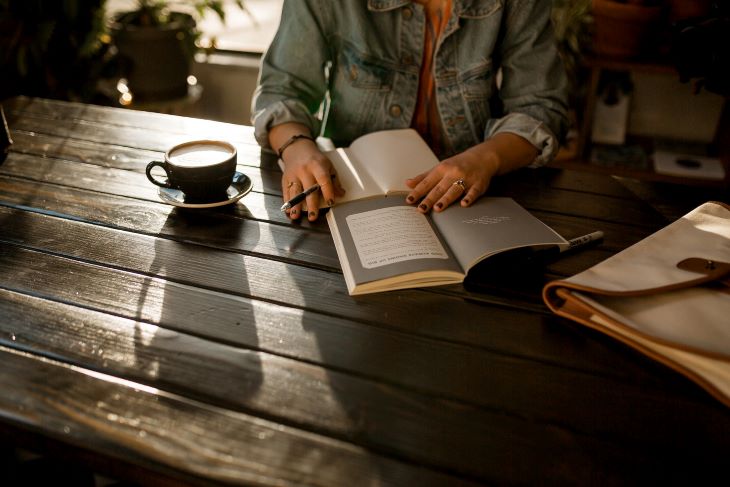 A woman sat at a table, journalling