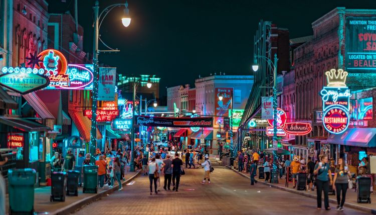 A city nightlife scene with lit up streetlights, bars and entertainment venues