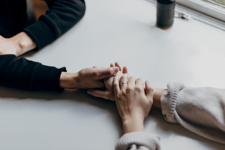 Two people holding hands at a table