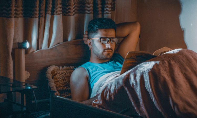 A man reading in bed recovering from Fentanyl addiction