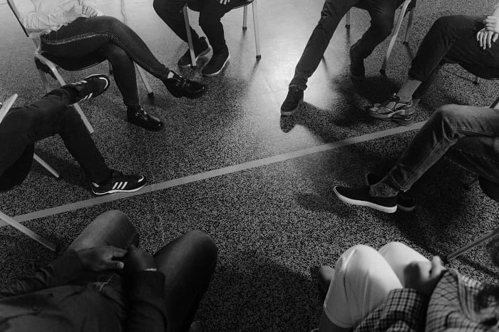 Black and white photo of a support group talking about post-covid-19 syndrome