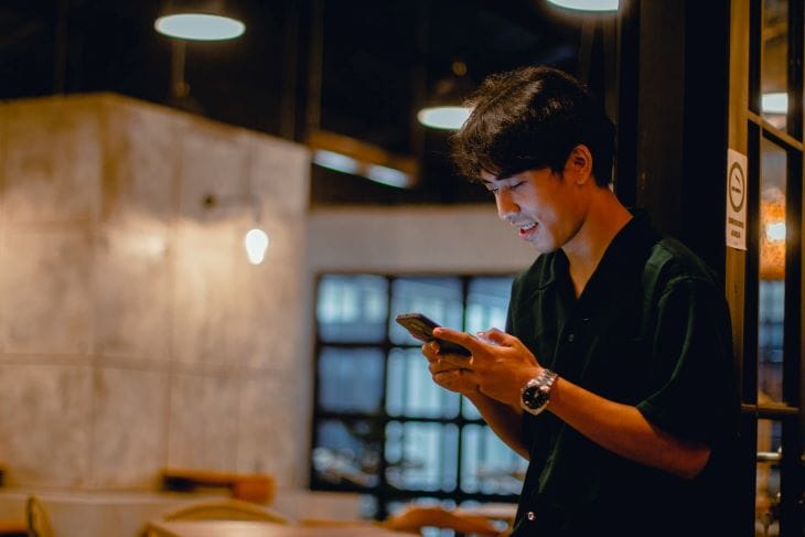 Man typing on a phone seeking suicide support