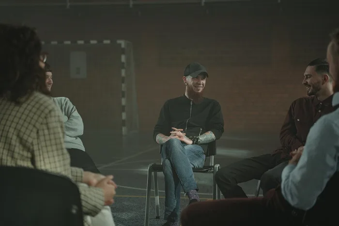 Mans smiling whilst sat with a suicide support group
