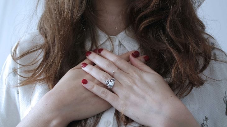 A woman with her hands on her chest