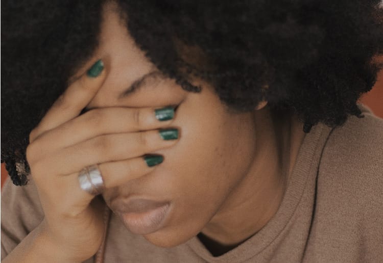 Person suffering from menopause and its mental health effects holding their head