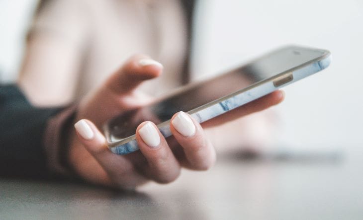 Person typing on a phone looking for help regarding menopause and mental health