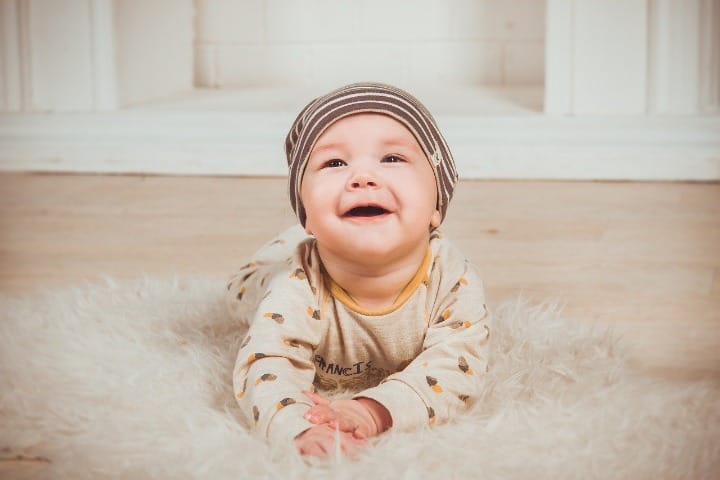 Photo of an infant crawling on a carpet