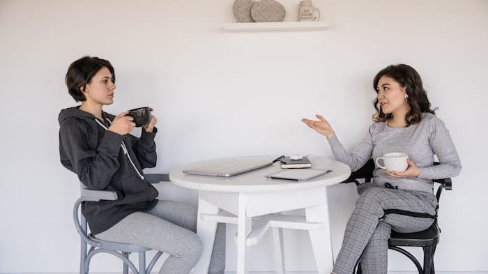 Two people sat at a table talking about menopause and mental health