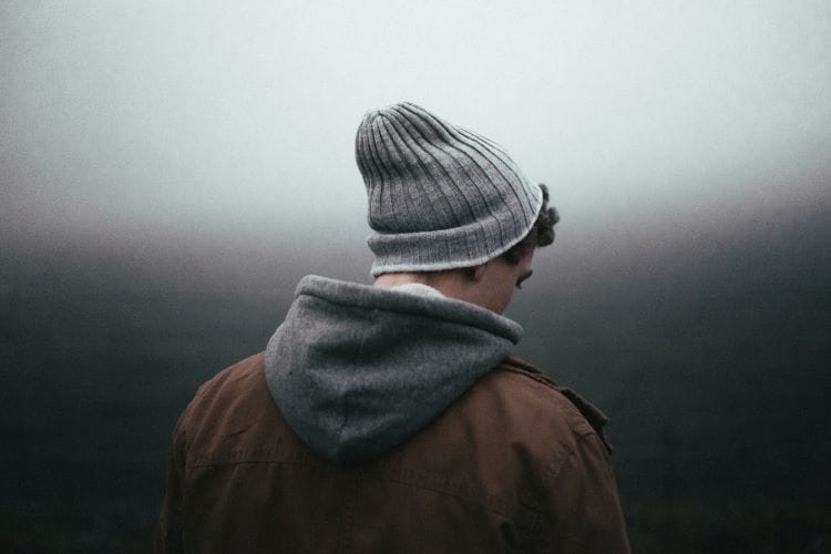Man stood in a dark space thinking about drug addiction