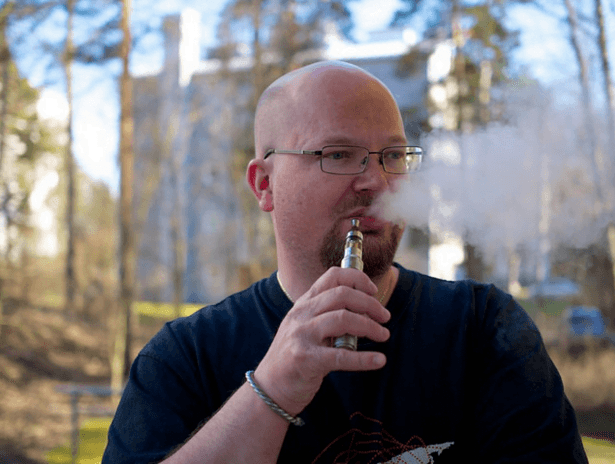 Man vaping thinking and thinking about how long it will take his lungs to heal