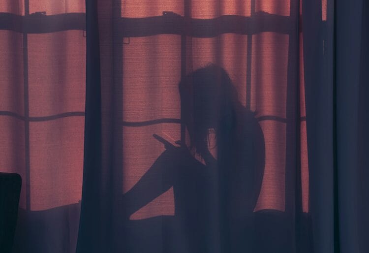 A woman hiding behind a curtain, secretively