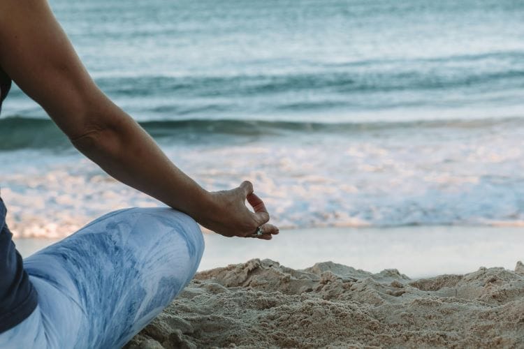 A woman meditating by the sea
