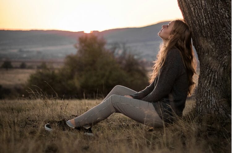 A woman sitting under a tree