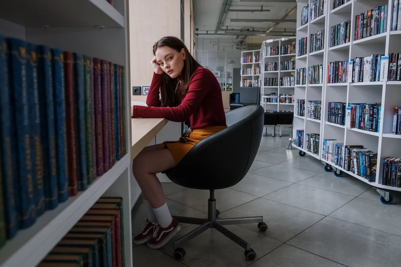 Young woman sat in a UK school struggling with mental health