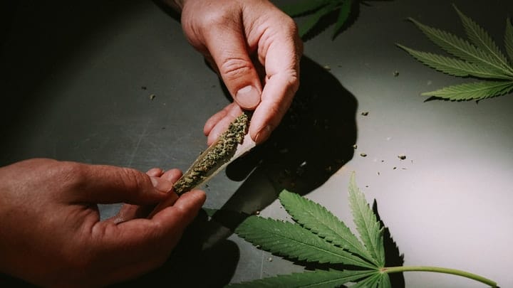 Man rolling a joint containing spice