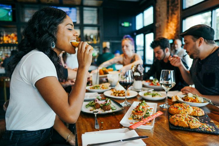 A table of people at a restaurant, smiling and eating
